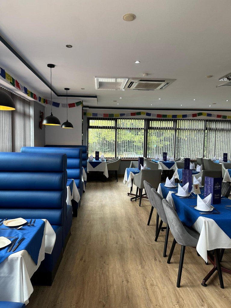 Blue leather booths beside tall windows