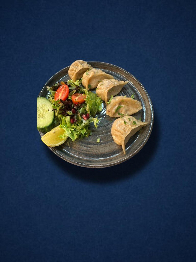 Steamed momos with salad and lime