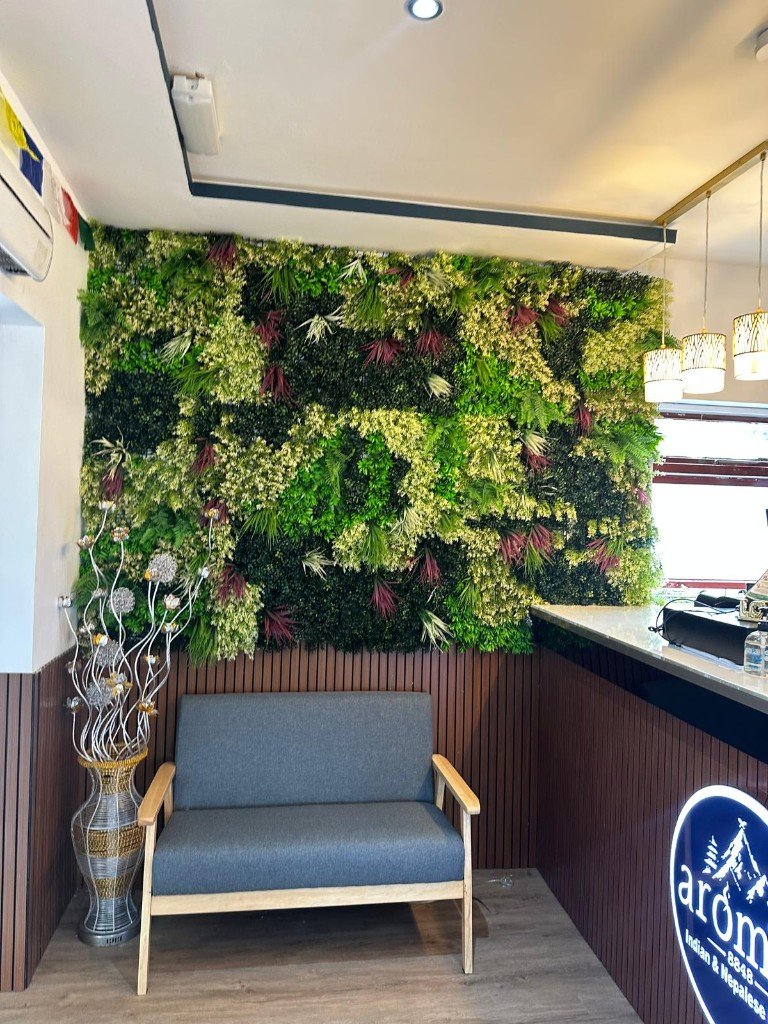 Grey sofa in front of the planted green wall